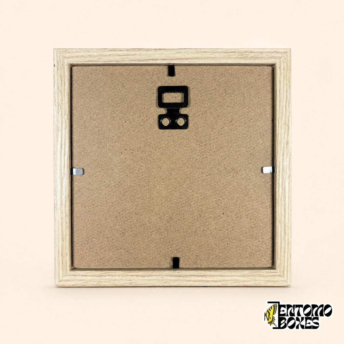 Parte trasera del marco de madera clara con tapa marrón, pestañas metálicas y colgador dentado