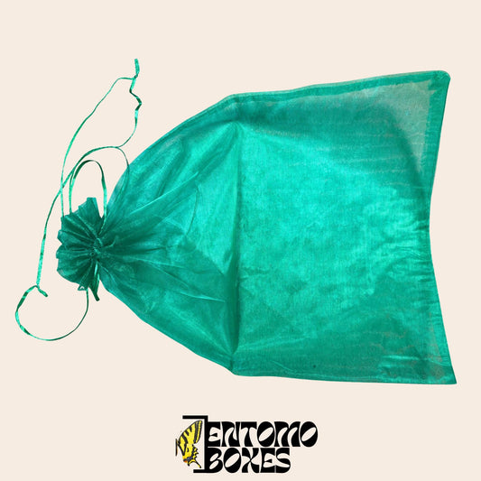 Folded green mesh breeding bag with drawstring on a beige background, alternate angle.